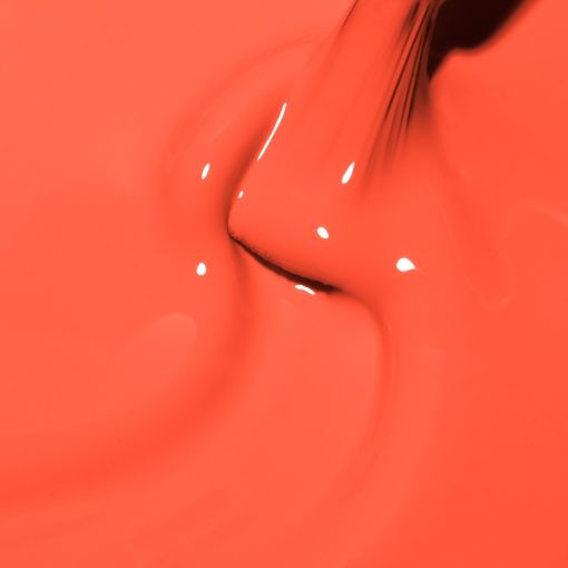 Naheaufnahme von leuchtender orangefarbener Farbe, die auf eine glatte Fläche träufelt.