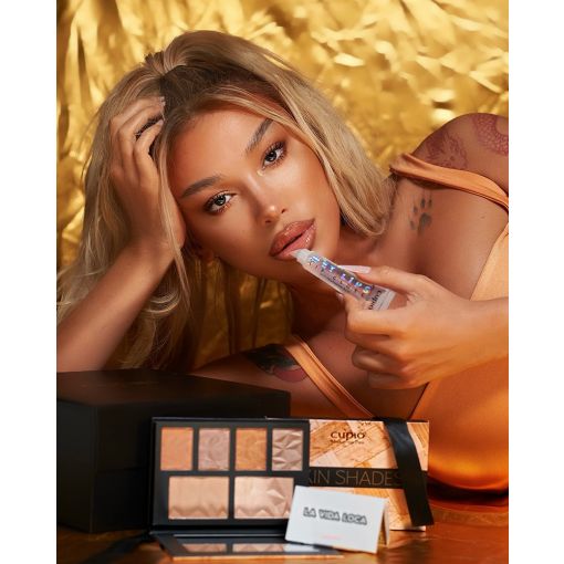 1000_1 Model mit Cupio Skin Shades Make-up Palette und Lippenstift auf goldenem Hintergrund