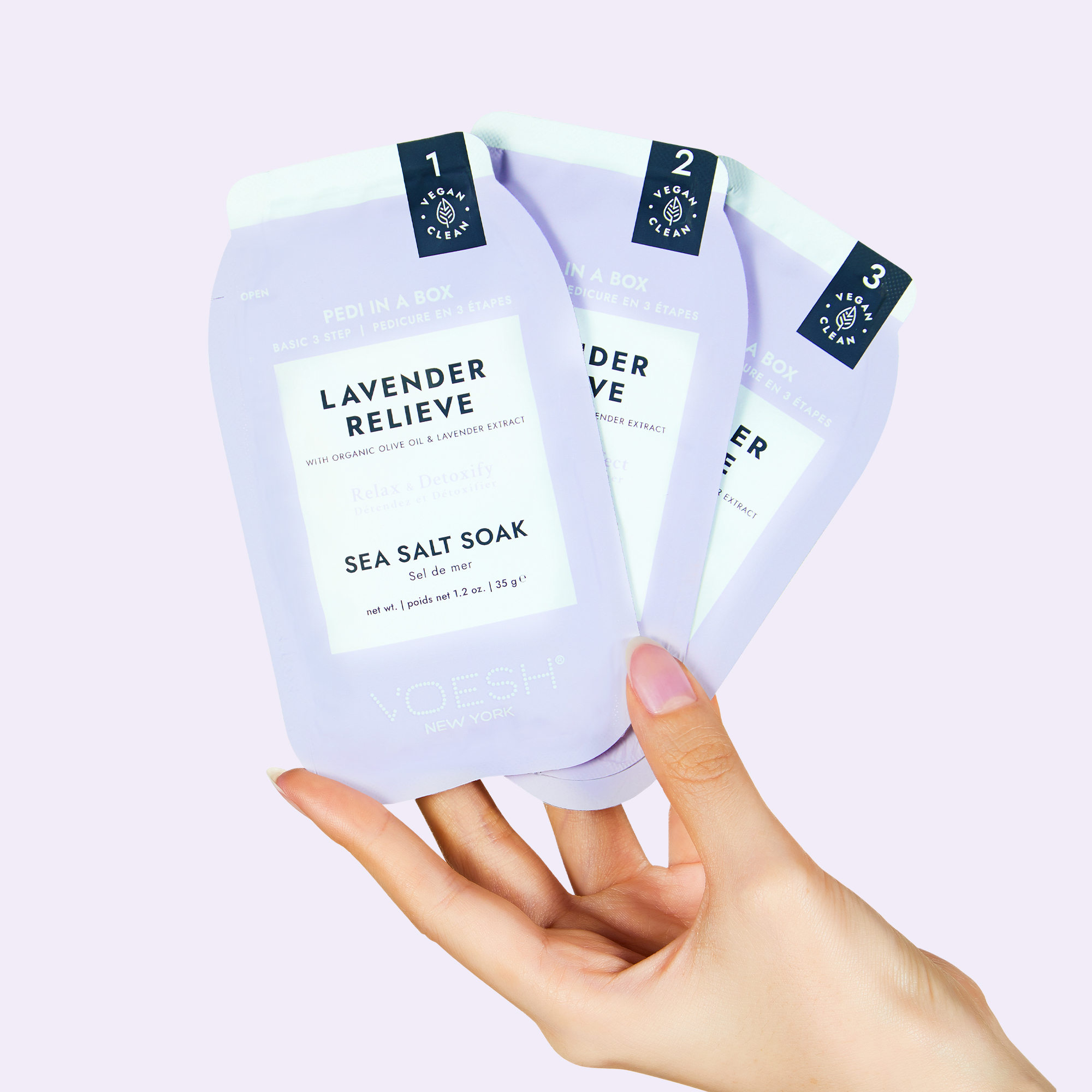Hand hält VOESH New York Pedi in a Box Lavender Relieve, ein veganes 3-Stufen-Pediküre-Set mit Sea Salt Soak und Lavendel