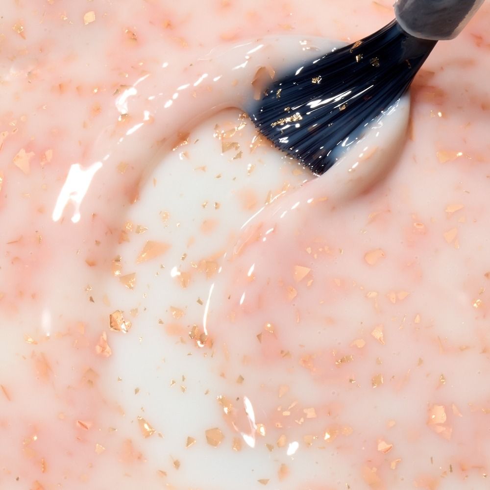 Nahaufnahme der Cupio Rubber Base Effect X Perfect Flakes Golden Touch 15ml, milchig-rosé mit schimmernden goldenen Flakes am Pinsel