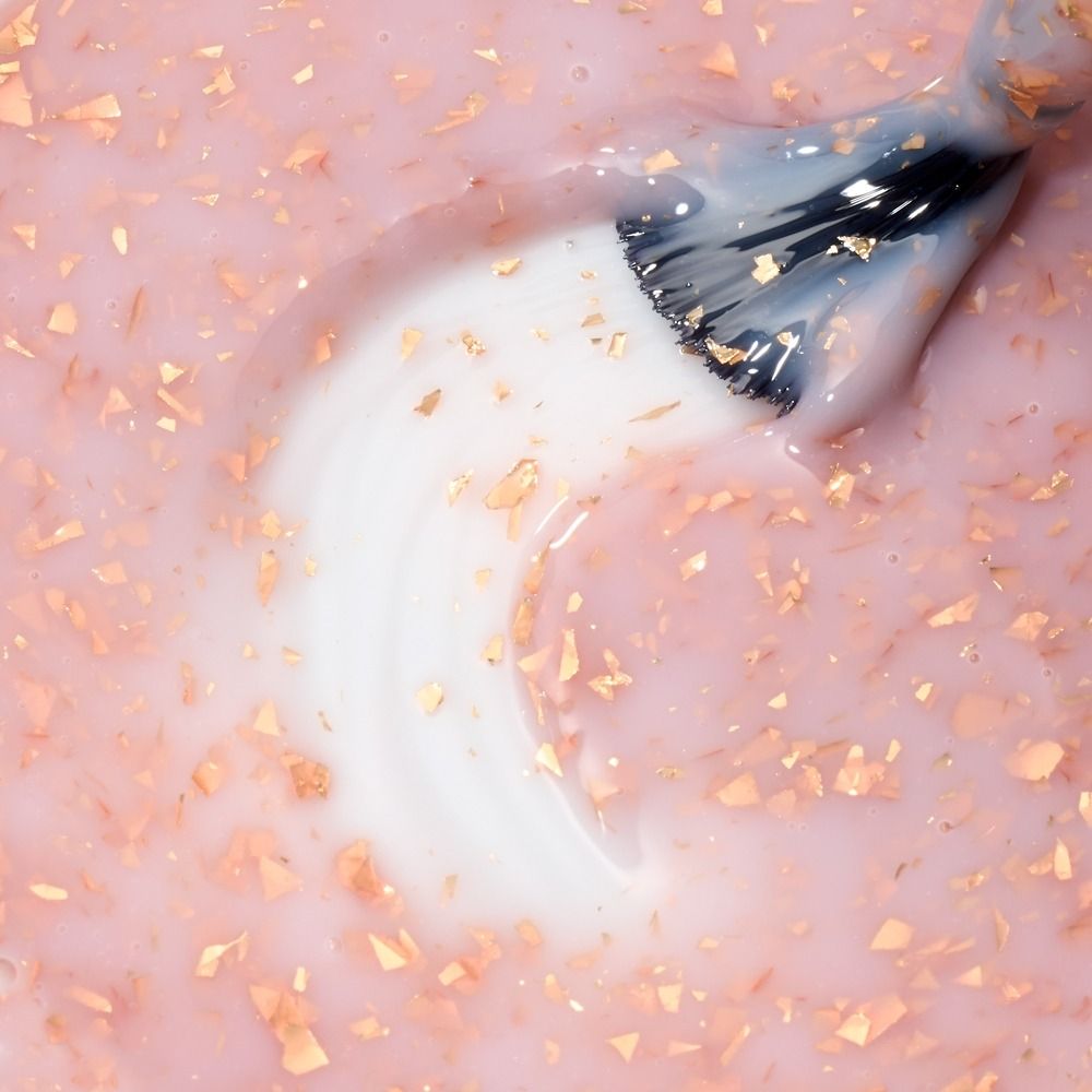 Nahaufnahme der Cupio Rubber Base Effect X Perfect Flakes You're Special 15ml: roséfarbene Rubber Base mit schimmernden Flake-Partikeln am Pinsel für elegante UV-Nageldesigns.