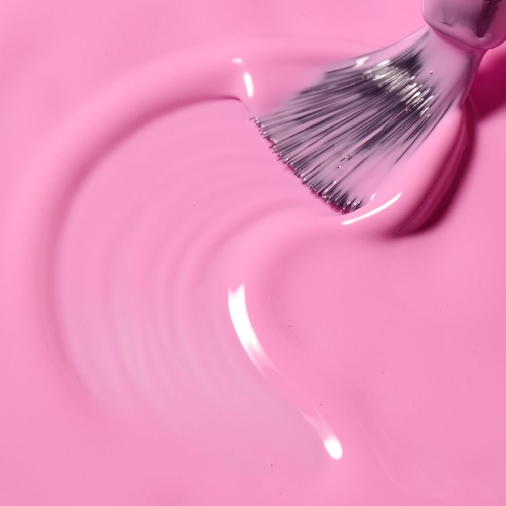 Makroaufnahme eines Nagellackpinsels in rosa Nagellack mit glänzender, flüssiger Textur – ideal für Maniküre, Nail-Design und Kosmetikprodukte