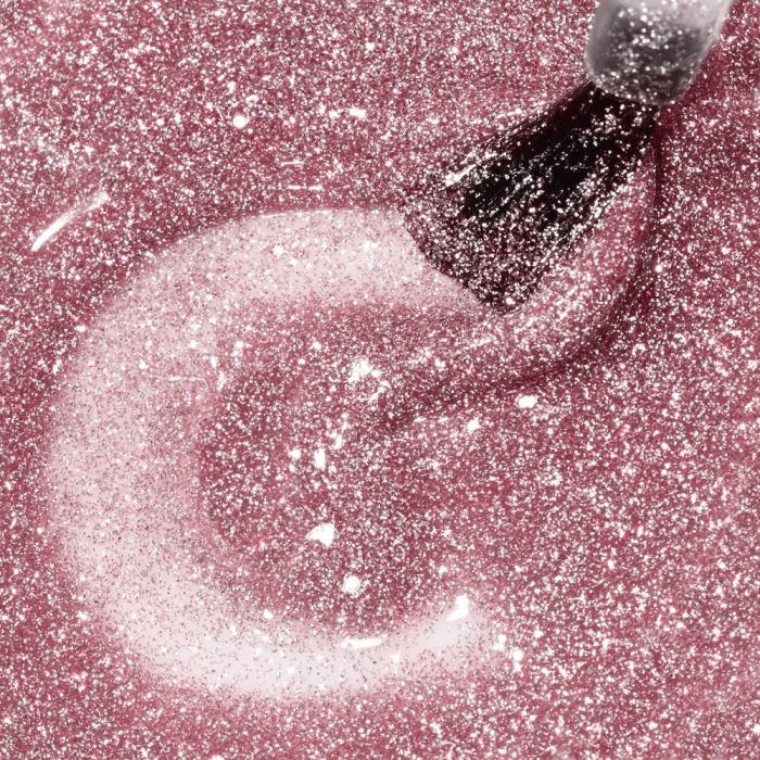 Nahaufnahme eines Pinsels, der glitzernden roséfarbenen Nagellack aufträgt – schimmernde Textur des Nagellacks