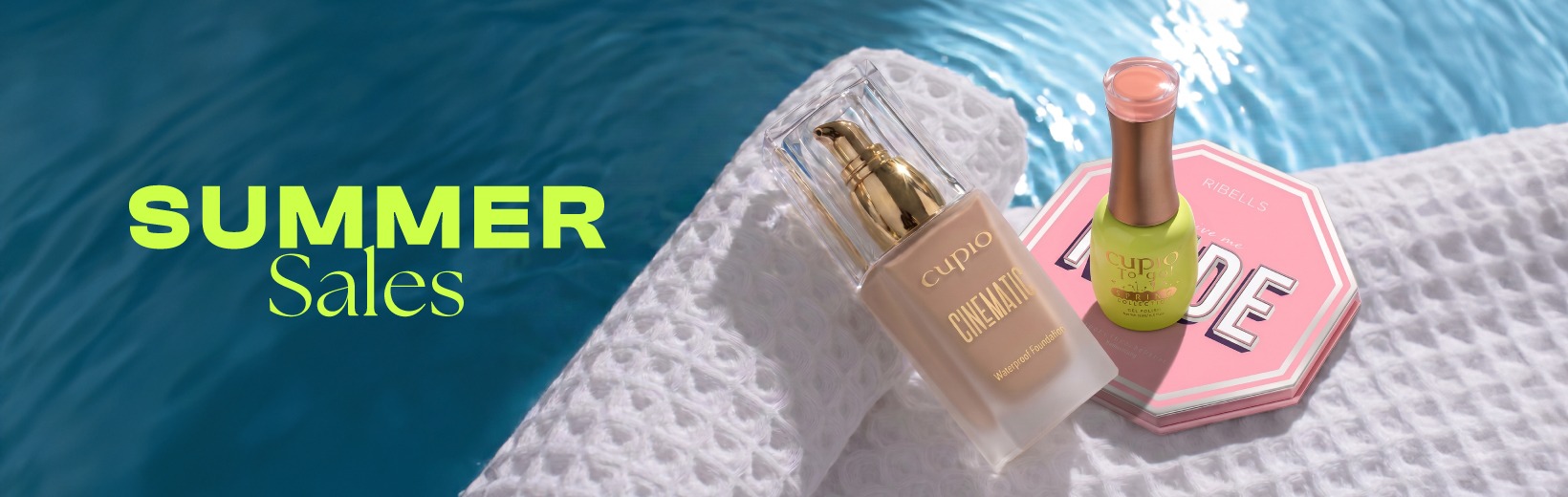 Cupio Kosmetikprodukte am Pool: Waterproof Foundation, grüner Nagellack und rosa Make-up-Palette auf weißem Handtuch mit Summer Sales Schriftzug
