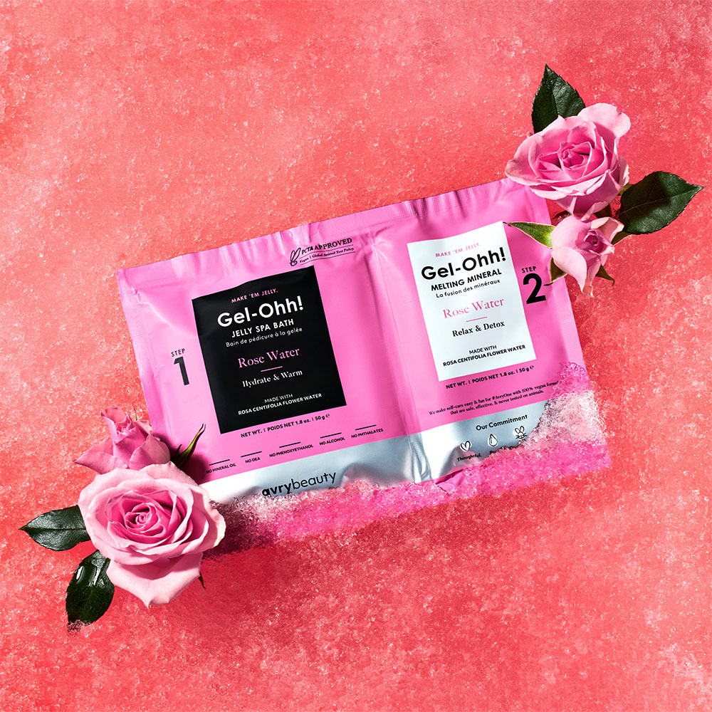 Verpackung des Gel-Ohh! Rose Water 2-Schritt Fußbad-Sets mit Jelly Spa Bath und Melting Mineral, dekoriert mit rosa Rosen auf pinkem Hintergrund