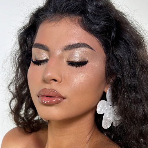 Porträt einer Frau mit goldigem Augen-Make-up und Blütenohrr