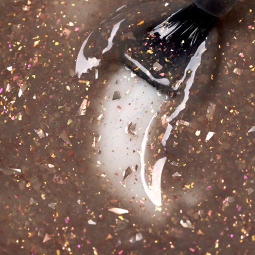 d0035_b_1-Kopie Nahaufnahme einer glitzernden Nagellackmasse mit bunter Flockenstruktur und Pinsel