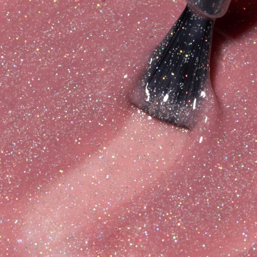 rubber_timeless_posh_glow_c8734_c Nahaufnahme von glitzerndem Nagellack in Rosa mit Pinsel