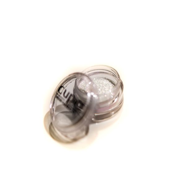 Offenes Döschen mit hellem Glitzer-Puder zur Anwendung in der Kosmetik