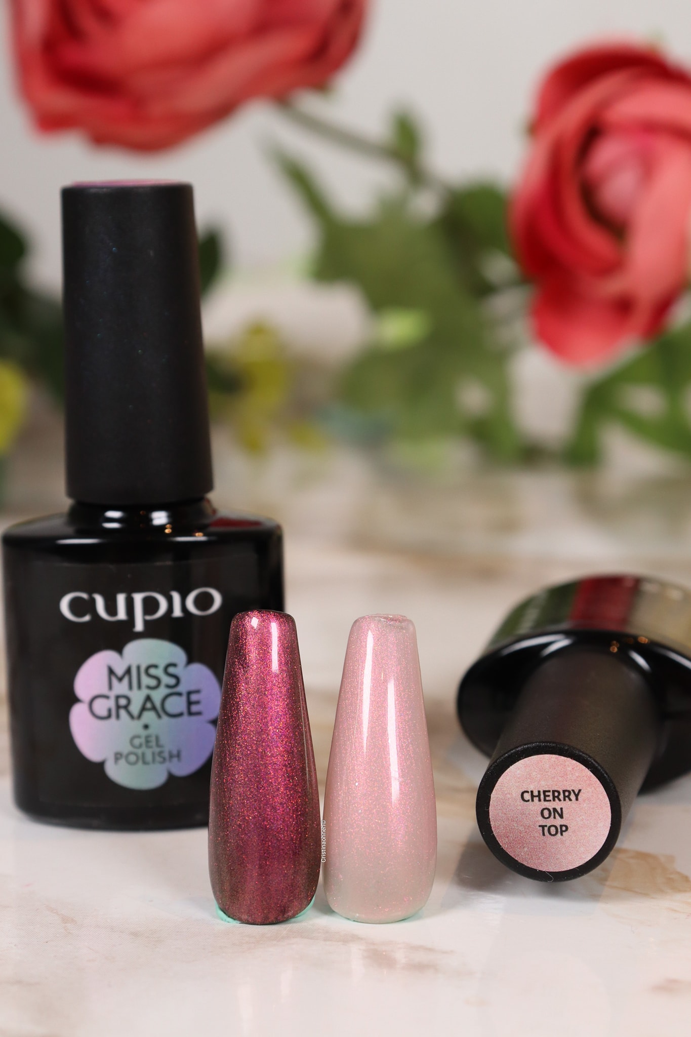 258841373_10221077892959763_2927173040089117260_n Cupio Miss Grace Gel Polish Flasche und zwei Nagellackproben in pinken Farbtönen auf einem Tisch