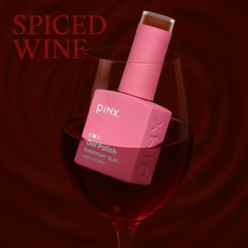 PINX Gel Polish Everyday Slay in pink, präsentiert in einem Weinglas mit Spiced Wine Hintergrund
