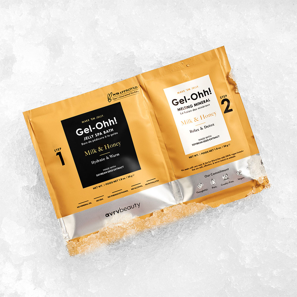 Zwei Beutel des avrvbeauty Gel-Ohh! Milk & Honey Fußpflege-Sets mit Jelly Spa Bath und Melting Mineral, arrangiert im Schnee