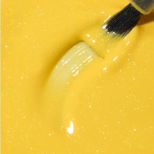 Nahaufnahme von glänzender gelber Acrylfarbe und Pinsel, ideal für kreative Projekte.