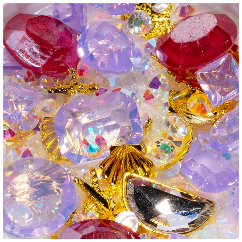 Bunte Mischung aus Strasssteinen, Glitzer und dekorativen Elementen in Nahaufnahme