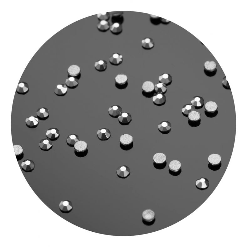 Eine Vielzahl von silbernen Strasssteinen auf einer schwarzen Oberfläche verteilt