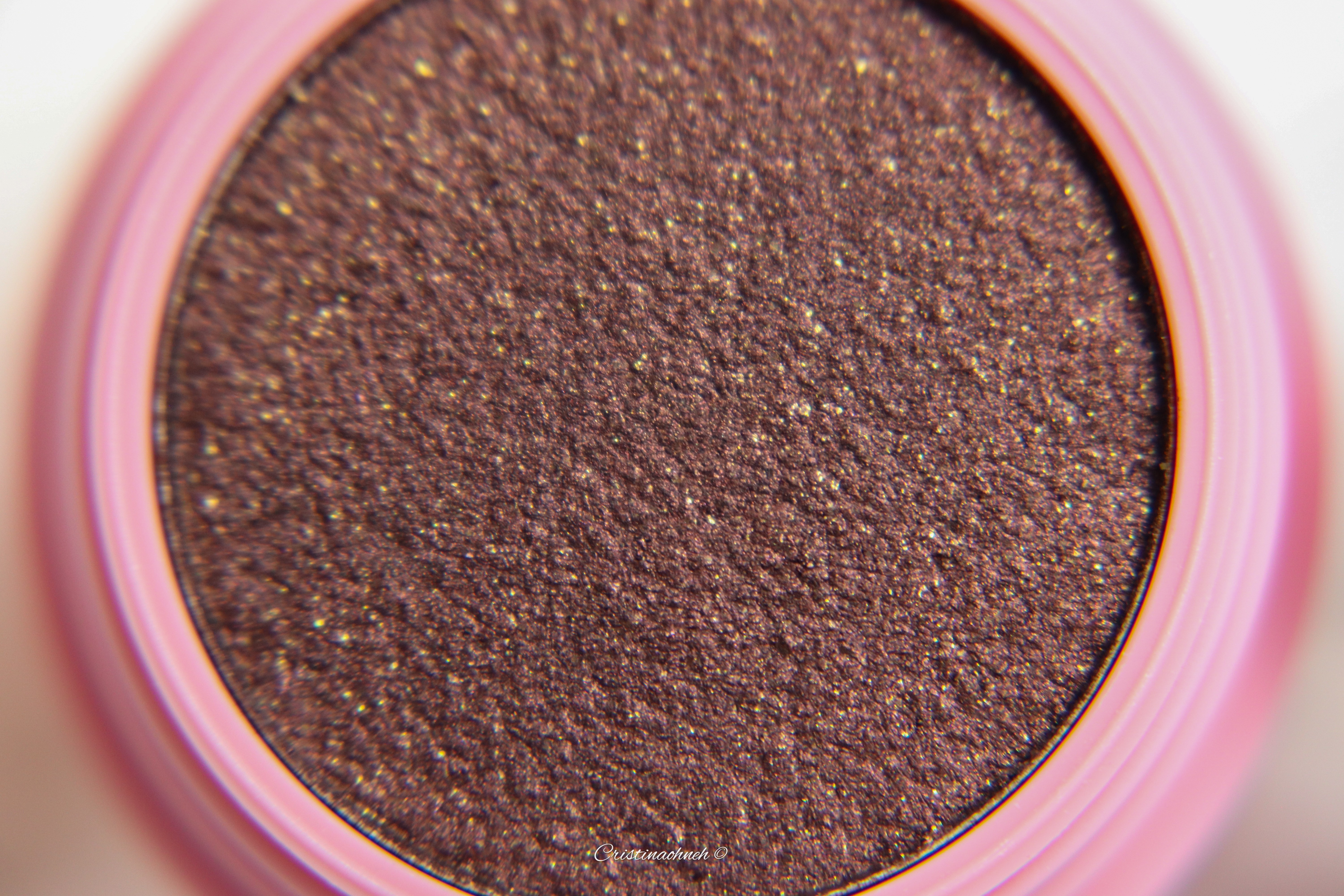 Detailansicht eines schimmernden braunen Lidschattens in einer Rosenfarbe Dose