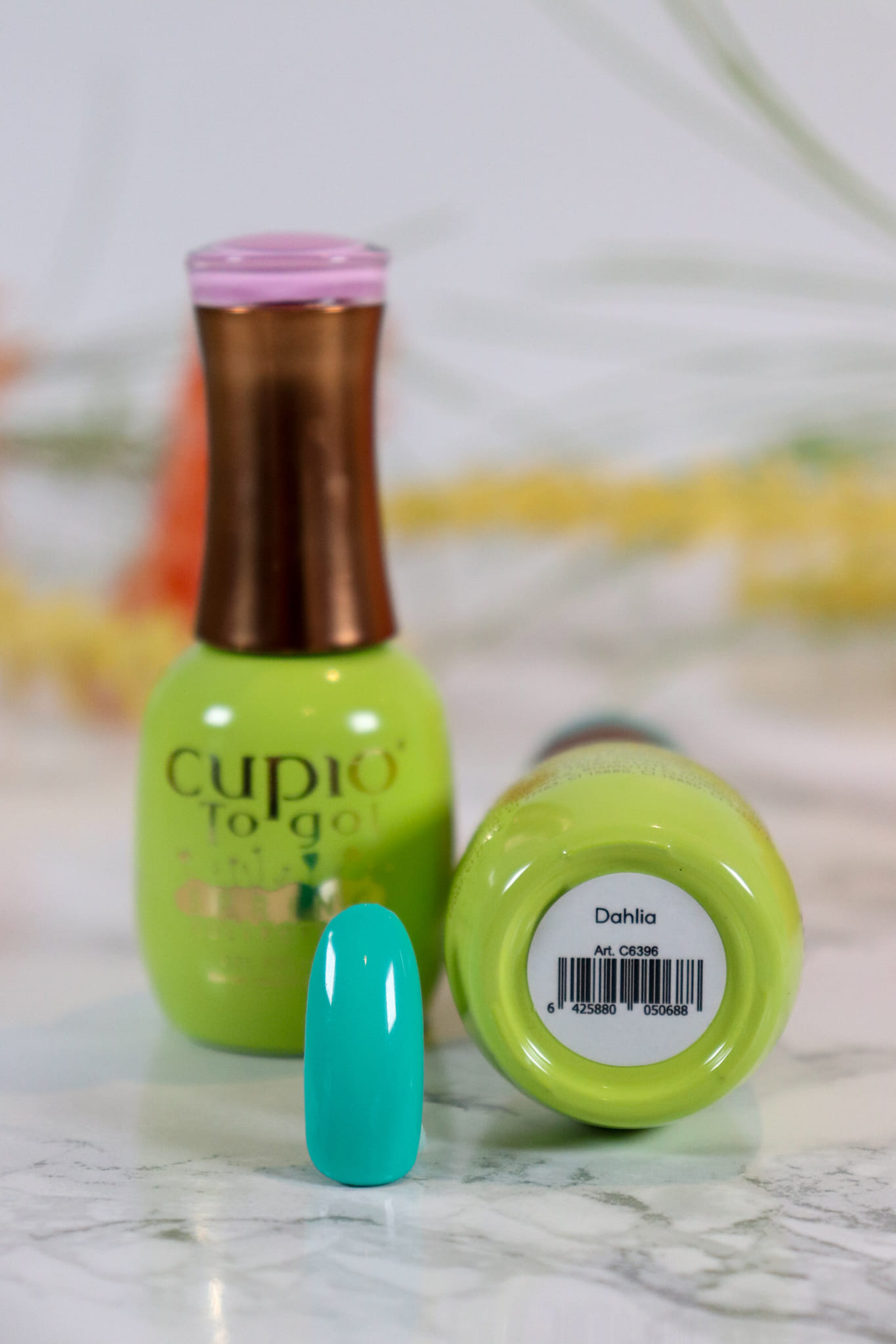 349175801_909011486863376_6619406034555980206_n Flasche Cupio To Go Nagellack in Grün und Türkisfarbige Farbe auf einem Tisch