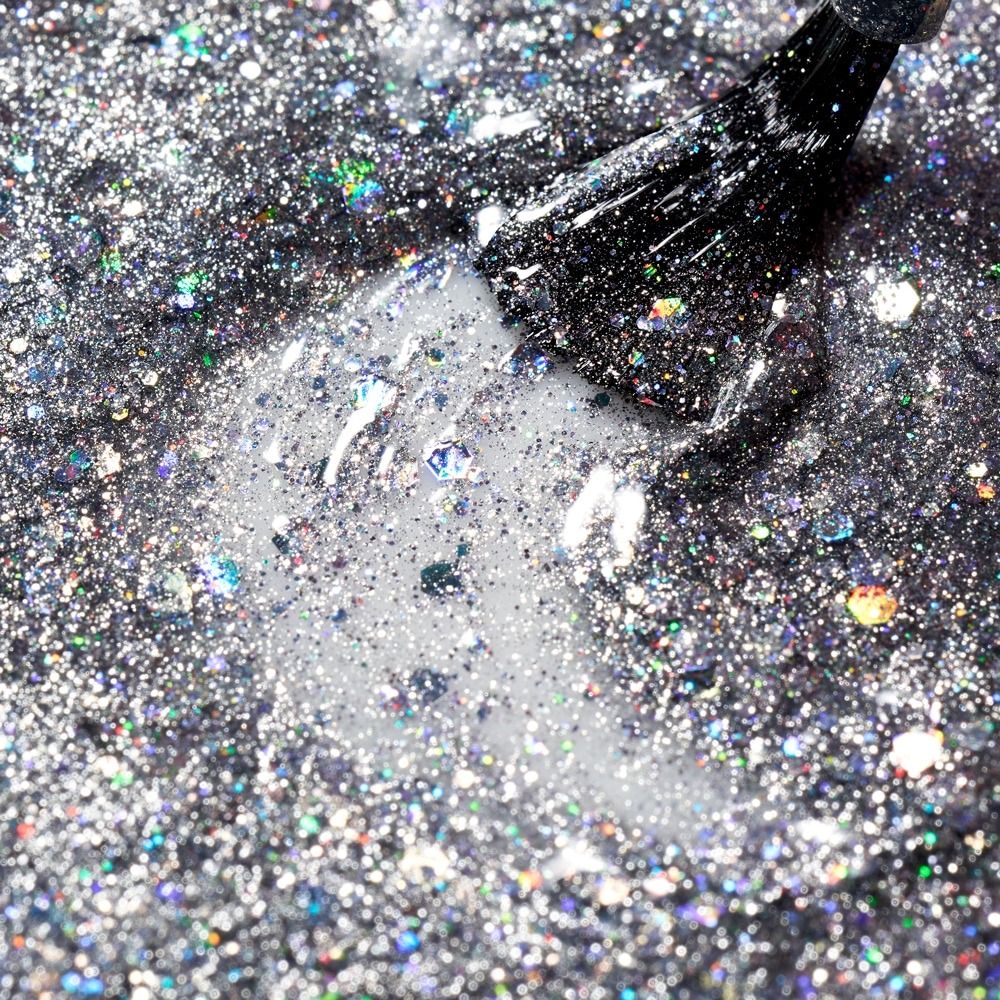 Pinsel mit transparentem Cupio Gellack Effect X Magnetto Galaxy Jupiter 8ml auf silbernem Glitter, irisierend und holografisch als Effekt-Layer oder Top Coat