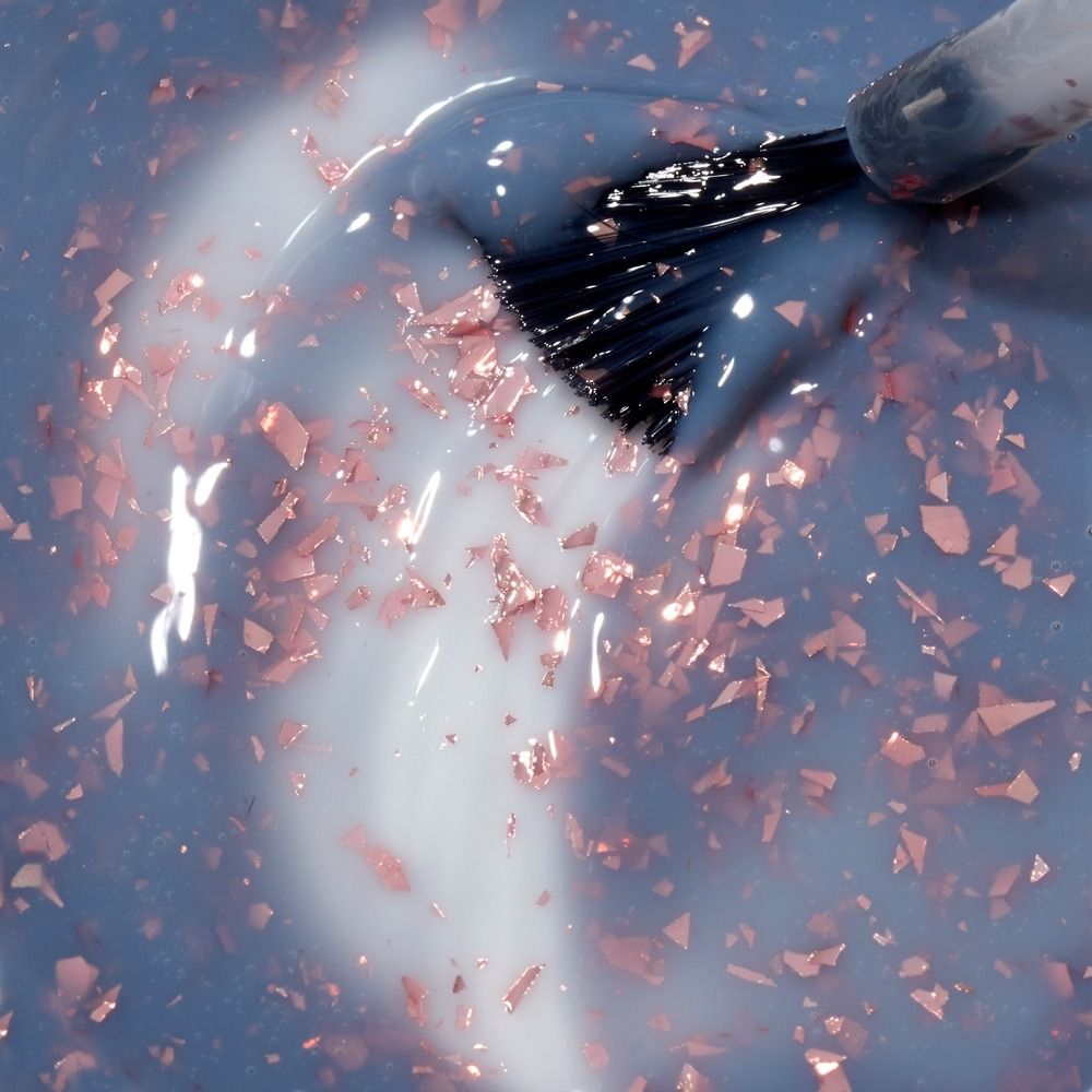 Nahaufnahme von Cupio Rubber Base Effect X Perfect Flakes Fearless 15ml, milchig-graue Rubber Base mit rosa schimmernden Flake-Partikeln und Pinselauftrag für elegante UV-Maniküre