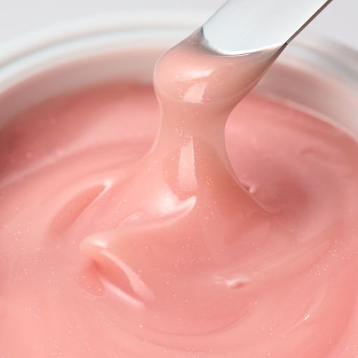 Nahaufnahme einer rosa Hautpflege-Creme auf einem Spachtel