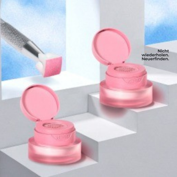 Zwei geöffnete rosa Make-up-Tiegel auf weißen Treppen, daneben ein Applikator mit rosa Schwämmchen und dem Schriftzug „Nicht wiederholen. Neuerfinden.“