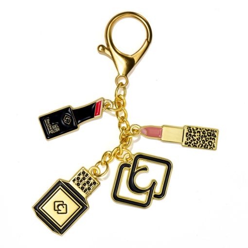 Goldfarbener Schlüsselanhänger mit Nagellack, Lippenstift un