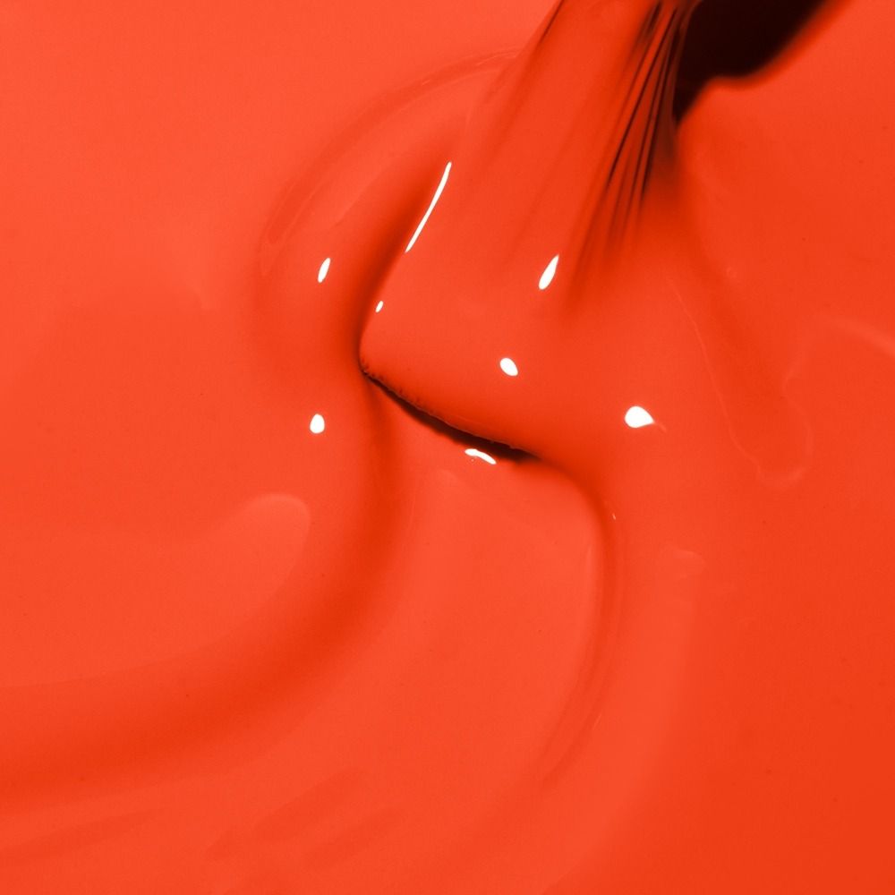 Nahaufnahme von leuchtend rotem, flüssigem Nagellack mit glänzender, cremiger Textur
