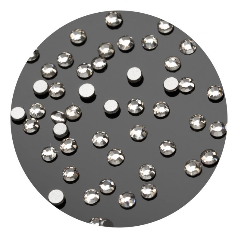 Detailaufnahme von Strasssteinen und runden Silberplättchen auf dunklem Untergrund