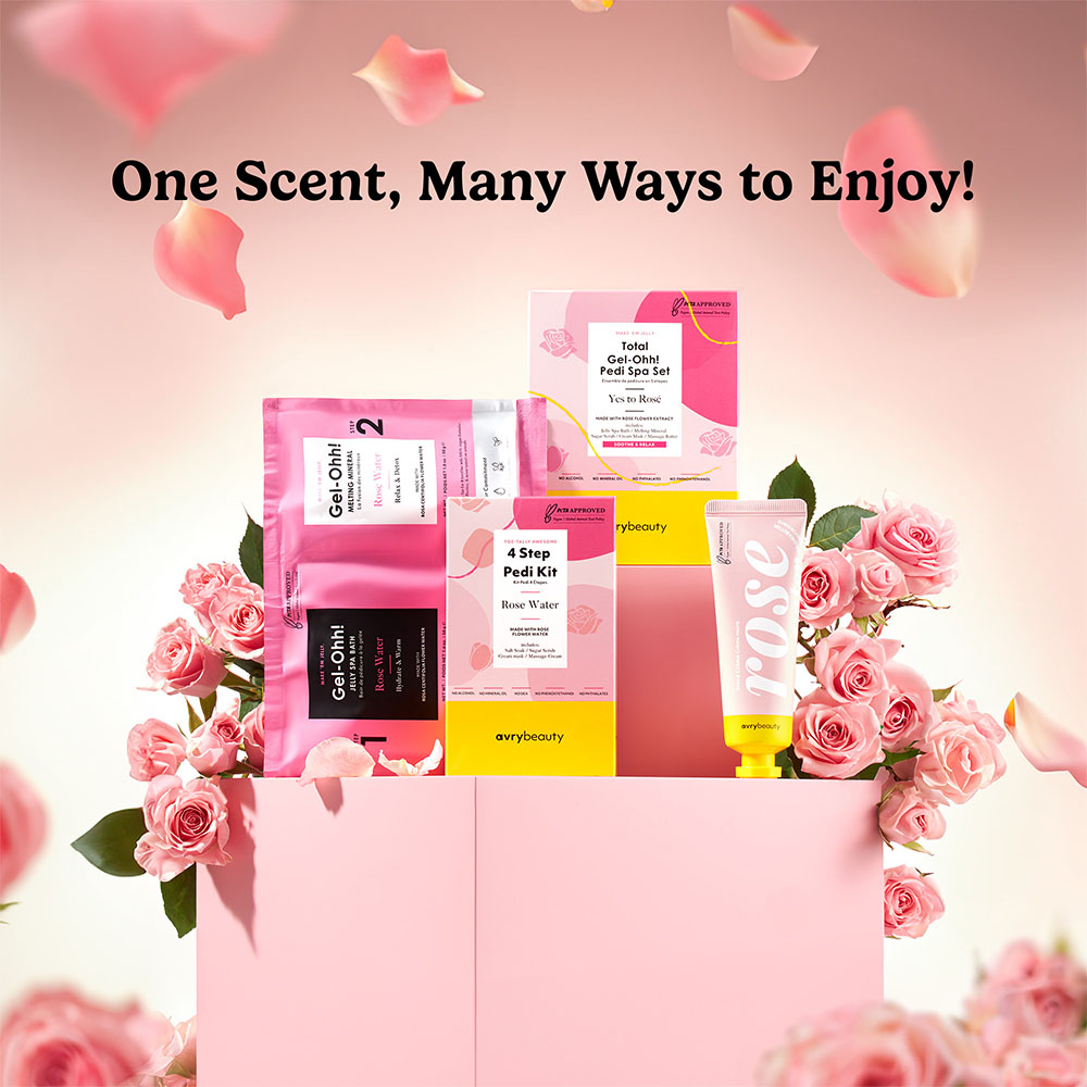 avrybeauty Rose Water Pedi Spa Set mit Gel-Ohh! Fußmaske, 4 Step Pedi Kit, Pedi Spa Sheet und Handcreme in rosa Geschenkbox, umgeben von Rosen