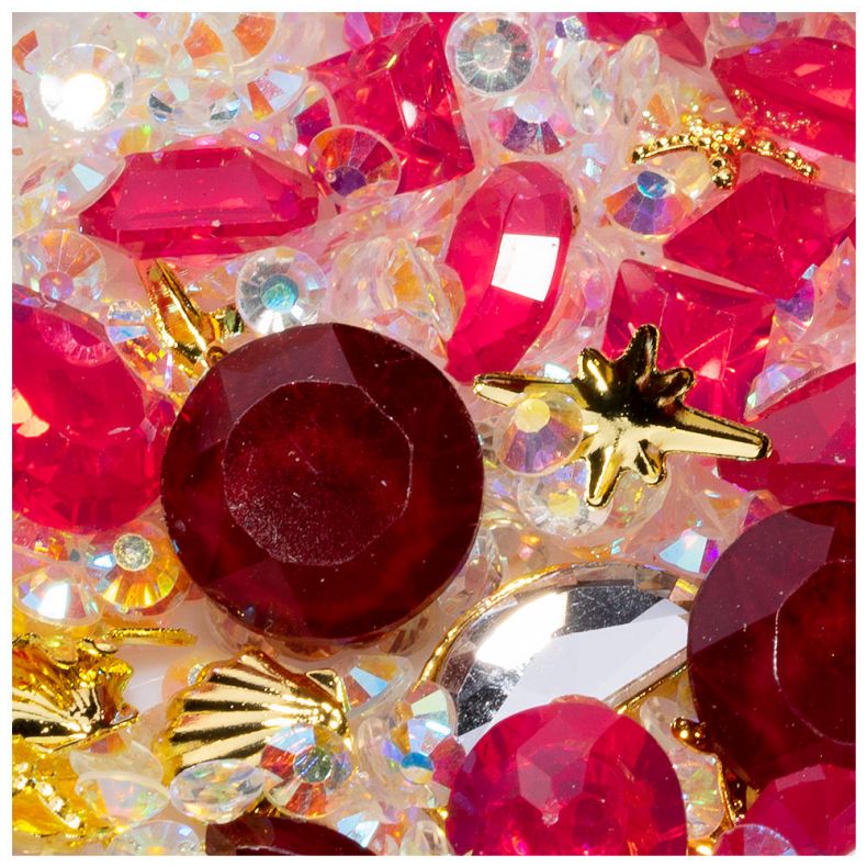Nahaufnahme von roten Schmucksteinen und glitzernden Verzierungen für kreative Bastelarbeiten