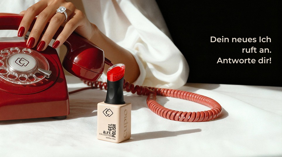 Hand mit rotem Nagellack und Ring am Telefon neben Nagellack