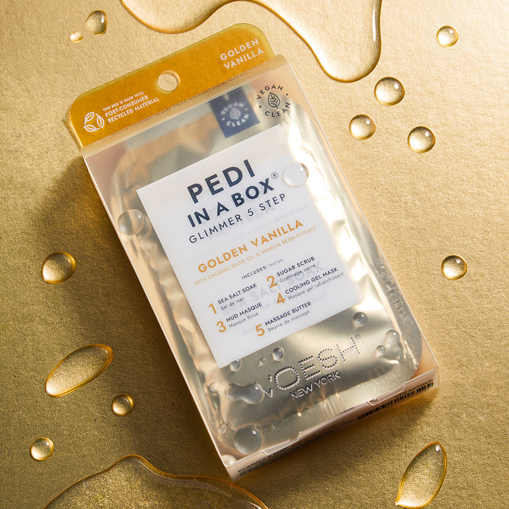 VOESH Pedi in a Box Glimmer 5 Step Golden Vanilla Pediküre-Set mit 5 Pflege-Schritten auf goldenem Hintergrund mit Wassertropfen