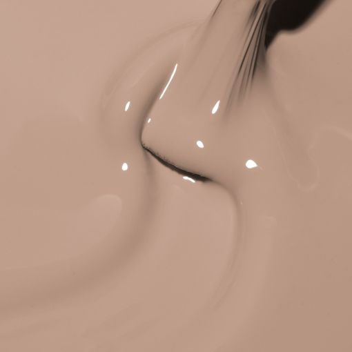 Flüssige, beige Farbe wird aus einer Düse gegossen, Nahaufnahme der Textur und des Glanzes
