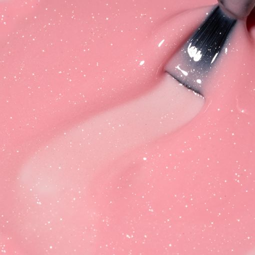 rubber_timeless_sparkling_nectarine_c8731_c Nahaufnahme von glitzernder rosa Paste, die mit einem Pinsel bearbeitet wird.