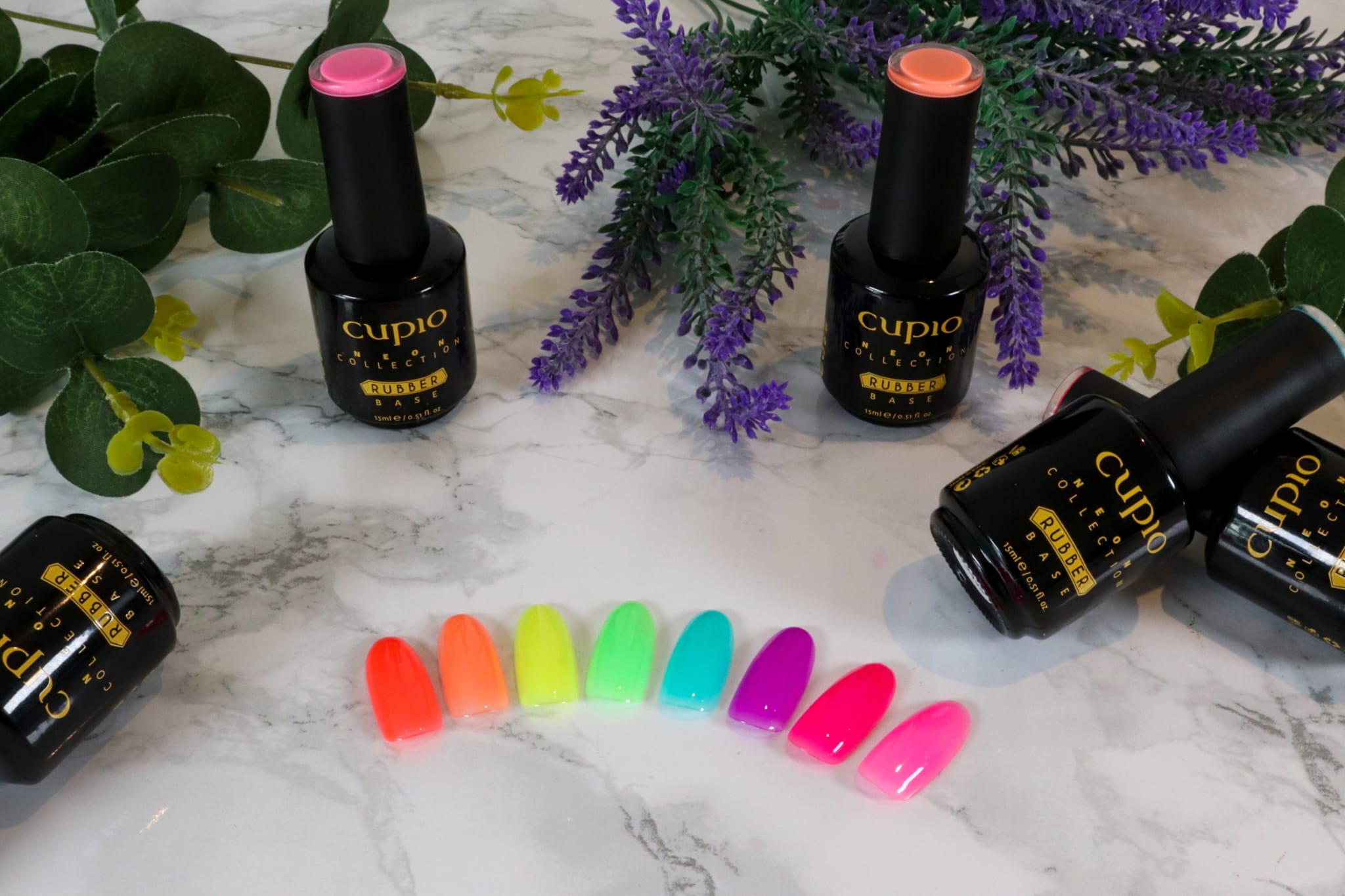 10 Bunte Nagellackproben und Cupio Rubber Base Produkte auf einem Tisch