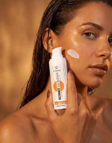 Nahaufnahme eines Models mit Cupio Sun Mineral Face Sunscreen SPF 50+ und sichtbarem Cremeauftrag auf der Wange
