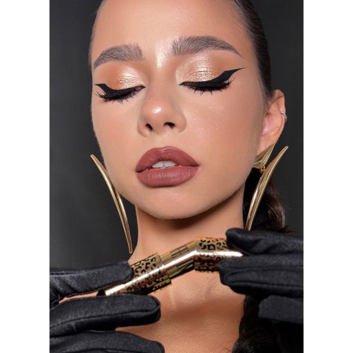 mobwife1 Model mit elegantem Make-up, verführerischem Eyeliner und goldenen Ohrringen, die Wimperntusche in den Händen hält.