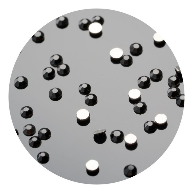 Detailaufnahme von glänzenden schwarzen und silbernen Strasssteinen auf schwarzem Untergrund