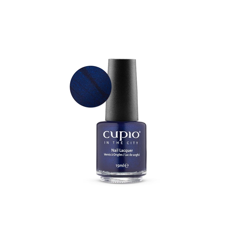 Flasche Cuccio In The City Nail Lacquer Nagellack 15 ml in schimmerndem Dunkelblau mit Farbkreis auf weißem Hintergrund