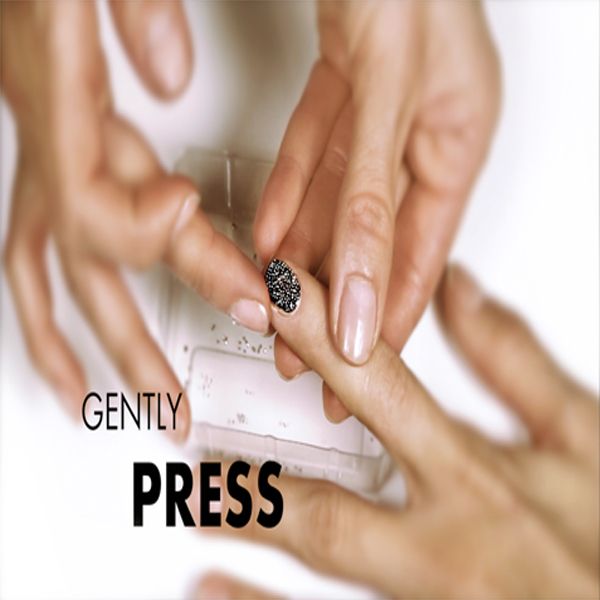 Hände bei der Anwendung von Nageldesign mit sanftem Druck auf den Nagel