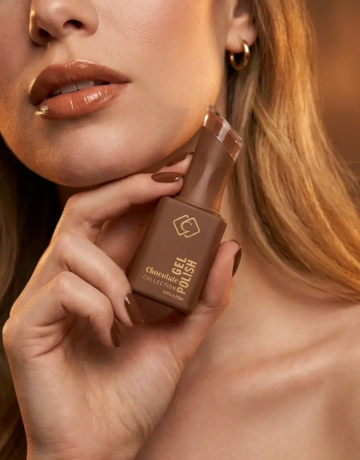 Frau hält den Catrice Melted Sun Cream Bronzer Golden Hour in der Hand, Nahaufnahme mit warmem Make-up und glänzenden Lippen