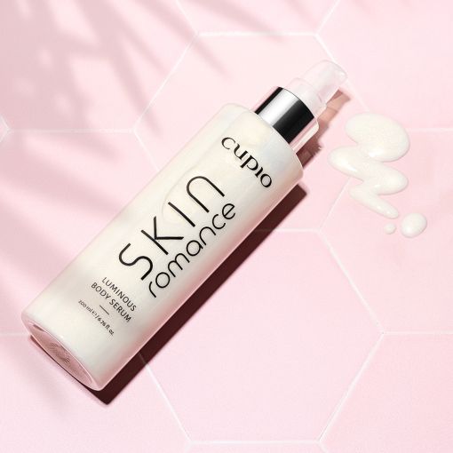 skin_romance_2_palm Flasche mit Cupio Skin Romance Luminous Body Serum auf rosa Hintergrund