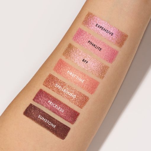 Arm mit schimmernden Lidschatten-Swatches in Rosé und Braun
