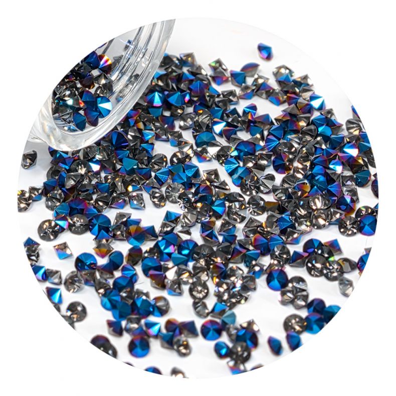 Bunte Strasssteine in verschiedenen Formen und Farben, verstreut auf einem weißen Hintergrund.