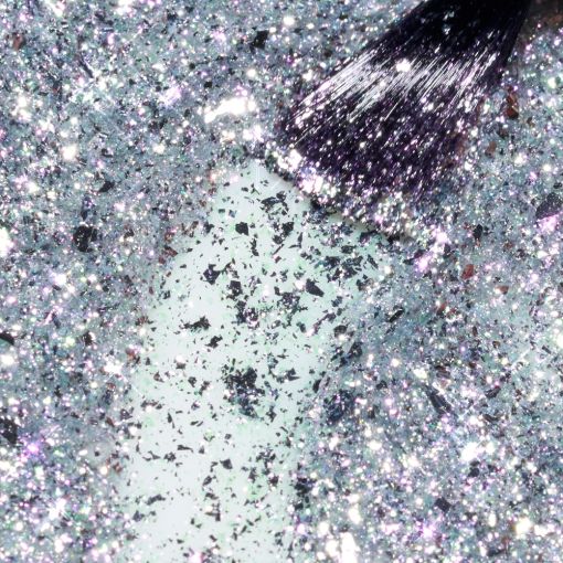 best_time_of_the_year_c9985_b Nahaufnahme von Glimmer auf einem weißen Pinsel, der in glitzerndem Material liegt.