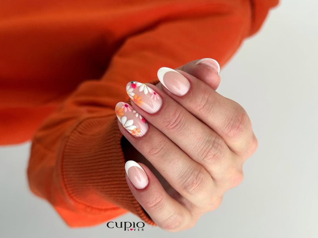 Nahaufnahme von gepflegten Händen mit bunten Blumennägeln und französischer Spitze
