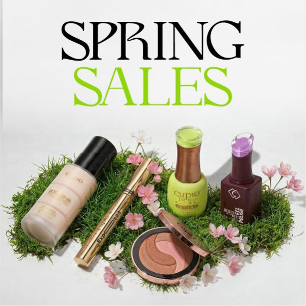 Frühlingsangebot mit dekorativer Kosmetik: Foundation, Mascara, Nagellack und Blush auf Moos mit rosa Blüten und dem Schriftzug Spring Sales im Hintergrund