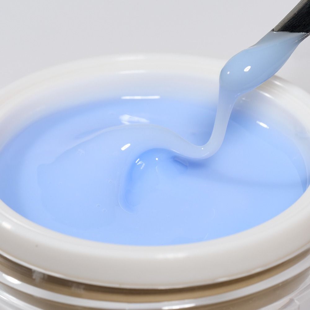 Nahaufnahme von hellblauem UV-Gel im weißen Tiegel, das mit einem Spatel entnommen wird – Nagelgel für Modellage und Naildesign
