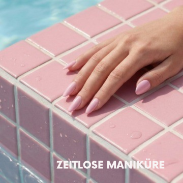 Hand mit zartrosa, mandelförmigen Kunstnägeln auf rosa Poolfliesen – Motiv für zeitlose Maniküre und Nageldesign