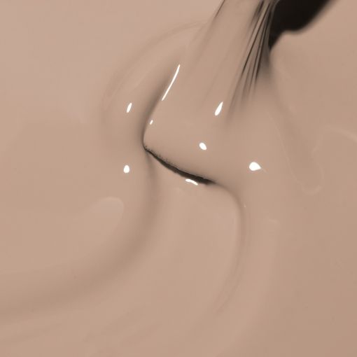Ein Pinsel taucht in eine beige Flüssigkeit ein, Nahaufnahme